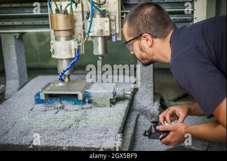 Ingenieur Arbeiter Techniker mit CNC-Fräsen Metallgravur Maschine in der Werkshalle. Stockfoto