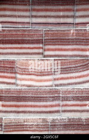 Wandstruktur mit Marmorblock. Wand aus Marmorblöcken in roten, weißen und grauen Farben Stockfoto