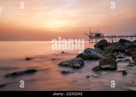 Juni 2021, San Vito Chietino, Abruzzen, Italien. Trabocchi Küste. Blick auf den Turchino Trabocco. Alte Fischmaschine im Morgenlicht mit seidigem Meer Stockfoto