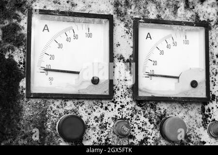 Zwei industrielle Quadratmeter zeigen einen Nullkraftpegel, Nahaufnahme eines rostigen alten elektrischen Bedienfelds. Vintage stilisiertes Schwarz-Weiß-Foto Stockfoto