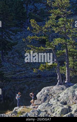 CHAMROUSSE, FRANKREICH, 23. September 2021 : Paar am felsigen Ufer des Lac Achard in Chamrousse am Ende eines Sommertages Stockfoto