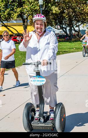 Miami Beach Florida, Lummus Park Serpentine Trail, hispanische Frau weiblich Reiten Segway übergewichtig übergewichtig fettleibig lächelnd, trägt Sicherheitshelm Stockfoto