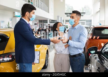 Vertriebsleiter gibt Schlüssel für die Familie aus dem Nahen Osten aus dem Auto Stockfoto