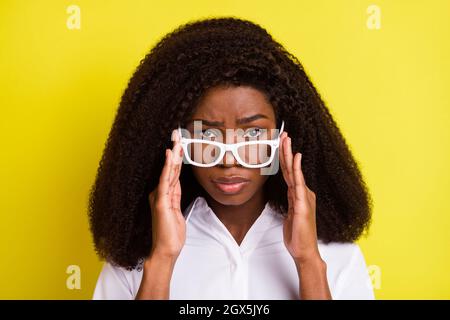 Foto Porträt von Geschäftsfrau trägt Brille suchen ernst unsicher isoliert lebendige gelbe Farbe Hintergrund Stockfoto