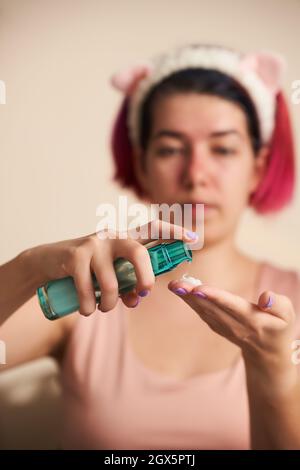 Frau verwendet feuchtigkeitsspendende Gesichtscreme. Hautpflege und schöne gesunde Haut Konzept. Stockfoto