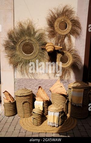 Korbarbeiten und Textilien zum Verkauf in Geschäften in der kleinen Stadt Arta, Mallorca. Körbe und Beutel werden durch Flechten von Palmblättern hergestellt. Stockfoto