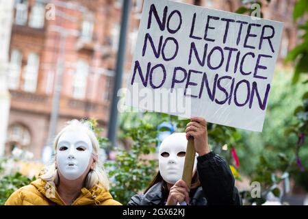 Manchester, Großbritannien. Oktober 2021. Zwei Demonstranten mit Plakaten nehmen an dem Protest gegen die Ungerechtigkeit der Frauen für staatliche Renten Teil. Vor der Konferenz der Konservativen Partei versammeln sich Menschen an der Emmeline Pankhurst-Statue auf dem Petersplatz. Die stille Kundgebung ist eine visuelle Botschaft an die Regierung, die die PHSOÕs-Erkenntnisse über Missstände in der Verwaltung offenbar nur ungern unterstützen will. Kredit: Andy Barton/Alamy Live Nachrichten Stockfoto