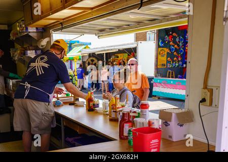 New Holland, PA, USA - 2. Oktober 2021: Menschen, die Lebensmittel auf der jährlichen Straßenmesse in einer kleinen Gemeinde in Lancaster County, PA, einkaufen. Stockfoto