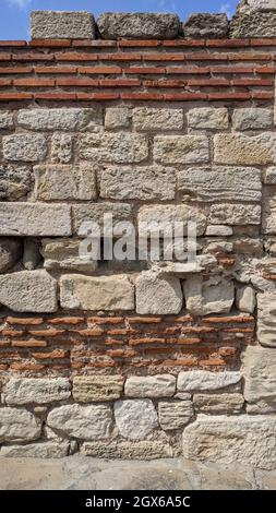 Steinmauer. Roter Ziegel und großer weißer Stein. Fragment einer alten Burg Stockfoto