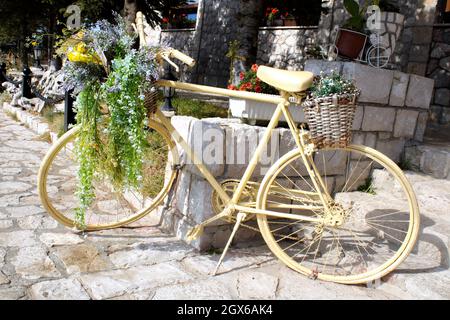 Dekoratives Fahrrad mit Blumen vor einem Gebäude Stockfoto