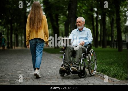 Ein behinderter Erwachsener im Rollstuhl bittet um Almosen Stockfoto