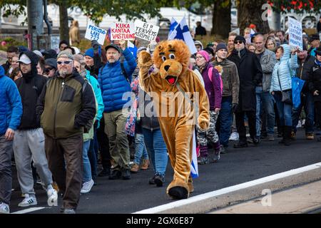 Maskottchen Löwe marschiert mit Demonstranten gegen die Impfung gegen das Coronavirus in Helsinki, Finnland Stockfoto