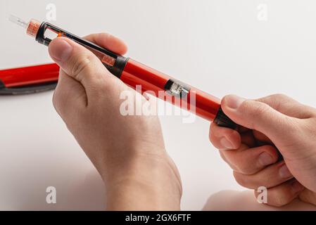 Medizin, Diabetes, Glykämie, Gesundheitswesen und Menschen Konzept - Nahaufnahmen der Hände des Menschen. Medizinische Geräte werden zur Selbstinjektion zur Behandlung von Diabetes eingesetzt. Stockfoto