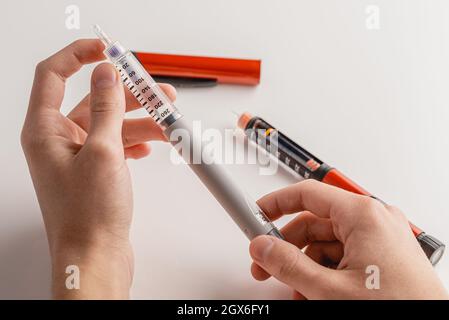 Medizin, Diabetes, Glykämie, Gesundheitswesen und Menschen Konzept - Nahaufnahmen der Hände des Menschen. Medizinische Geräte werden zur Selbstinjektion zur Behandlung von Diabetes eingesetzt. Stockfoto