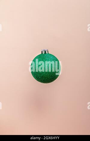 Grüne Weihnachtskugel isoliert auf rosa Hintergrund Stockfoto