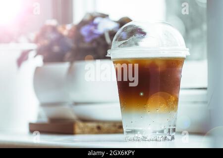 Ein kaltes, doppelschichtiges Espresso-Tonic sitzt auf einer Fensterbank in einem Café. Stockfoto