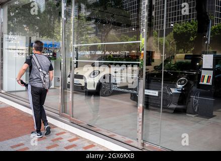 Ein Fußgänger geht an dem britischen Automobilhersteller Mini vorbei, der dem deutschen Automobilhersteller BMW gehört, dem offiziellen autorisierten Autohändler in Hongkong. Stockfoto