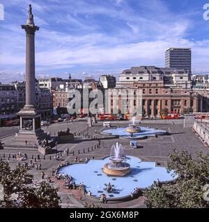 Historisches 1997Archiv Luftaufnahme mit Kopierraum Blick auf Touristen in den 1990er Jahren Trafalgar Square mit Brunnen und blauen Stein Becken neben Lord Nelsons Craigleith Sandsteinstatue auf einer korinthischen Säule aus Dartmoor-Granit zum Gedenken an Admiral Horatio Nelson, der bei der Schlacht von Trafalgar mit Canada House Beyond starb, wurde an einem sonnigen blauen Himmel der 90er Jahre gesehen Sommertag in City of Westminster London England Stockfoto