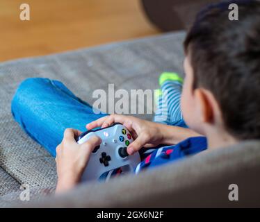 WIEN, ÖSTERREICH - 4. MAI 2018: Kleiner Junge spielt Xbox One. Xbox One ist eine Reihe von Heimvideospielkonsolen der achten Generation, die von Microsoft entwickelt wurden. Stockfoto