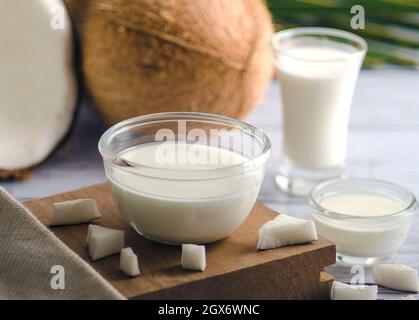 Reine Kokosmilch in drei verschiedenen Glasbehältern. Nahaufnahme. Vor weißem Hintergrund, unscharf. Stockfoto