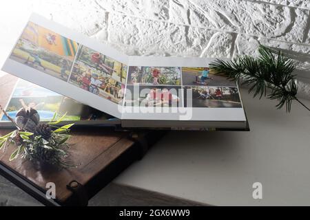 Luxus Holz Fotobuch, Holzkiste mit Sommerfotos gedruckt und Flash-Karte auf Leinen natürlichen Hintergrund. Fotobuch für Familienerinnerungen. Speichern Sie Ihr Stockfoto