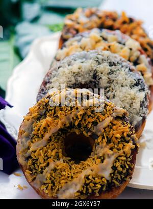 Donuts mit verschiedenen Topping in einer Reihe. Stockfoto