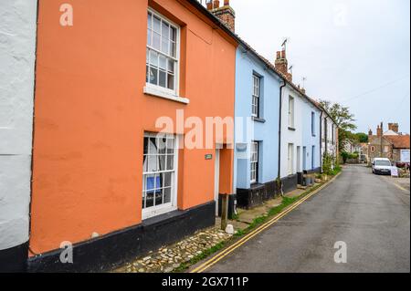 High Street in Blakeney Dorf ist eine charmante Straße mit historischen Häusern mit gerenderten oder Feuerstein Fassaden voller Charakter, Norfolk, England. Stockfoto