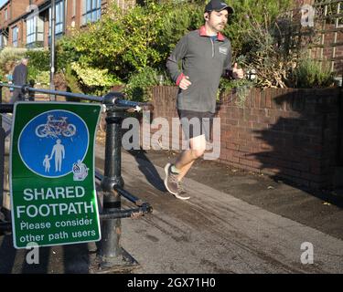 September 2021 - Läufer passiert ein gemeinsames Wegweiser am Hafen in Bristol, England, Großbritannien. Stockfoto