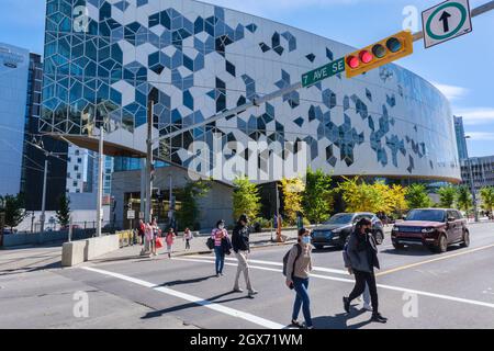 Calgary, Alberta, Kanada - 27. September 2021: Menschen überqueren die Straße vor der Calgary Public Library Stockfoto