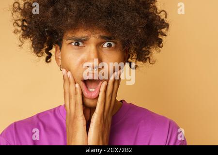 Mann mit lockigen Haaren ist über etwas erstaunt Stockfoto