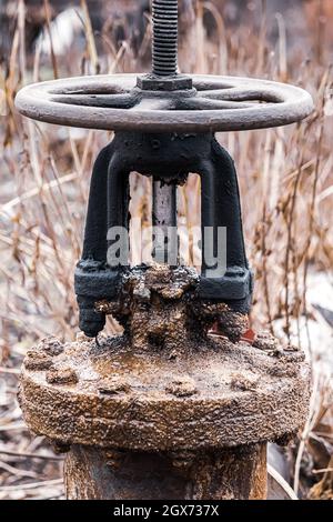 Großes altes rostliches Ventil am Rohr. Verlassene Sanitäranlagen. Stockfoto