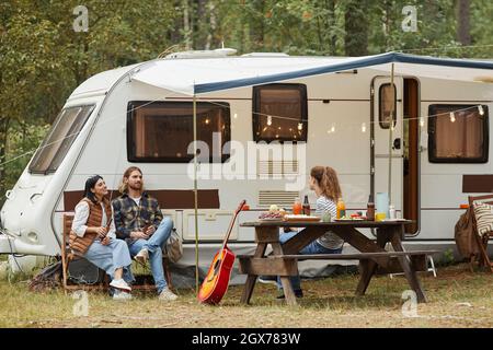 Weitwinkel-Ansicht von Freunden genießen im Freien, während Camping mit van im Wald, Kopierer Platz Stockfoto