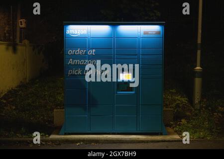 Amazon Hub locker gesehen in der Nacht auf dem Parkplatz des Kenley Bahnhof, South London. Stockfoto