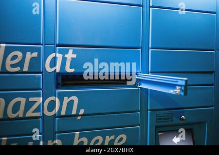 Amazon Hub locker gesehen in der Nacht auf dem Parkplatz des Kenley Bahnhof, South London. Stockfoto