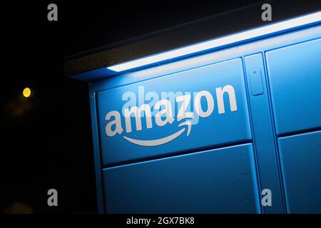 Amazon Hub locker gesehen in der Nacht auf dem Parkplatz des Kenley Bahnhof, South London. Stockfoto