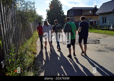 Kovrov, Russland. 12. August 2017. Teenager, die mit ein- und zweistöckigen Häusern die Straße entlang gehen Stockfoto