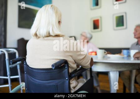 Rückansicht einer weißhaarigen älteren Frau, die im Rollstuhl im Pflegeheim sitzt, Platz zum Kopieren Stockfoto