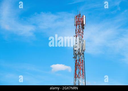 Telekommunikationsturm mit Mobilfunkantennen gegen blauen Himmel Stockfoto