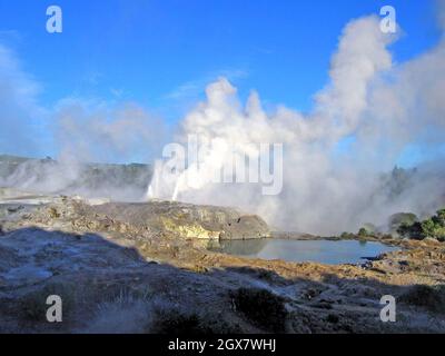 Pohutu Geysir bricht am 17. August 2004 über dem Whaka Thermal Valley in Rotorua, Neuseeland, aus. Der Geysir befindet sich in der Vulkanzone Taupo und ist eine der wichtigsten Touristenattraktionen auf der Nordinsel. Die Gegend wird auch von den Einheimischen von Whaka Village genutzt, die im Sommer auf dem Geysir spielen und im warmen Wasser schwimmen, unter dem sie den Spitznamen Bluies nannten. Stockfoto