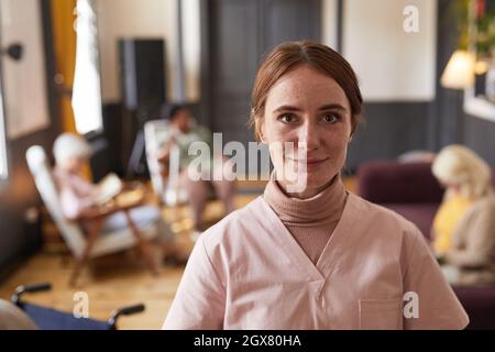 Vorderansicht Porträt einer lächelnden jungen Frau in Uniform im Pflegeheim, Platz kopieren Stockfoto