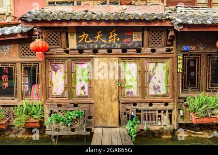 Yunnan, China - 22. März 2016: Altes Holzhaus, das in eine Kneipe in der alten Stadt Lijiang umgewandelt wurde. Stockfoto