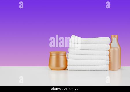 Stapel Handtücher, Flaschen mit Shampoo auf weißem Tisch Stockfoto