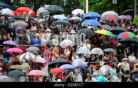 Racegoers mit Regenschirmen besuchen den Ladies Day im Regen am 16. Juni 2011 in Royal Ascot. Stockfoto