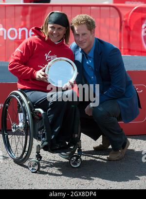 Prinz Harry posiert mit Diane Roy aus Kanada, die beim Women's Wheelchair Race auf Rang drei kam, nachdem sie am 22. April 2012 beim Virgin London Marathon 2012 Trophäen übergab. Stockfoto