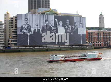 Ein riesiges Foto der britischen Königsfamilie auf einem Gebäude an der Themse am 28. Mai 2012 in London, England. Errichtet zur Feier des Diamantenjubiläums von Königin Elizabeth II. Das 70 mal 100 Meter große Foto zeigt die königliche Familie auf dem Balkon des Buckingham Palace während der Feierlichkeiten zum Silberjubiläum im Jahr 1977 Stockfoto