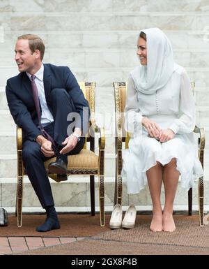 Catherine, Herzogin von Cambridge und Prinz William, Herzog von Cambridge, ziehen ihre Schuhe aus, als sie die Assyakirin-Moschee in Kuala Lumpur am 4. Tag einer Diamond Jubilee Tour durch den Fernen Osten besuchen. Stockfoto