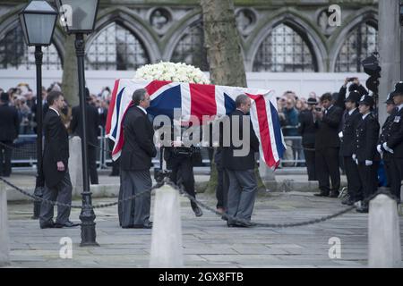 Der Sarg der ehemaligen britischen Premierministerin Margaret Thatcher kommt an, um auf einen Waffenwagen gebracht zu werden, der von der Königstruppe Royal Horse Artillery während ihres feierlichen Begräbnisses in der Church of St. Clement Danes in London gezogen wird. Stockfoto