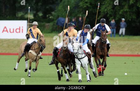 Prinz Harry (Mitte links) und Prinz William, Herzog von Cambridge (Mitte rechts) nehmen am 16. Juni 2013 an einem Charity-Polo-Spiel im Beaufort Polo Club in Tetbury Teil. Stockfoto