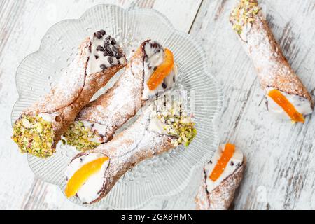 Direkt über Schuss sizilianischer Cannoli auf einer Glasplatte Stockfoto
