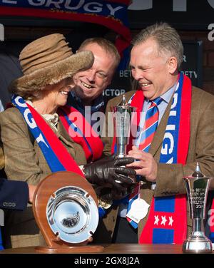 Camilla, Herzogin von Cornwall scherzt, als sie Steve Preston, dem Besitzer des Pferdes Sire De Grugy, dem Gewinner des Queen Mother Champion Chase beim Cheltenham Festival auf der Pferderennbahn in Cheltenham am 12. März 2014, eine Trophäe überreicht. Stockfoto